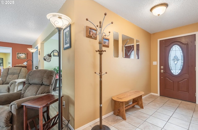 foyer featuring light tile patterned floors, baseboards, and a textured ceiling