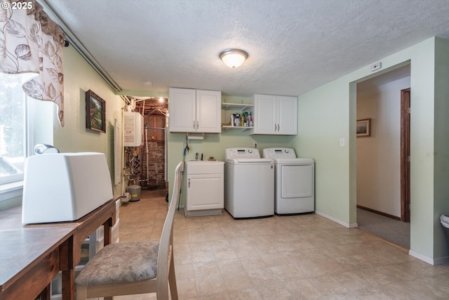 laundry room with a sink, a textured ceiling, washing machine and dryer, cabinet space, and baseboards