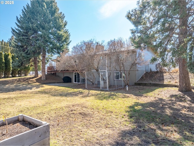 rear view of house featuring a yard and a deck