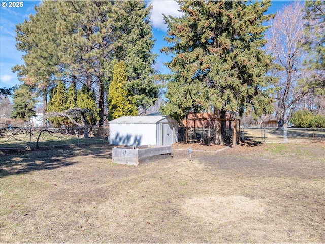 view of yard featuring a storage shed, an outdoor structure, and fence