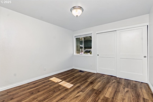 6841 SW Sussex St, Beaverton, OR 97008 - unfurnished bedroom with dark wood-type flooring, baseboards, and a closet