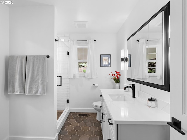 full bathroom with a shower stall, vanity, baseboards, tile patterned floors, and toilet