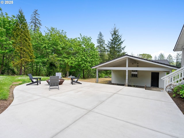 view of patio featuring concrete driveway and a carport