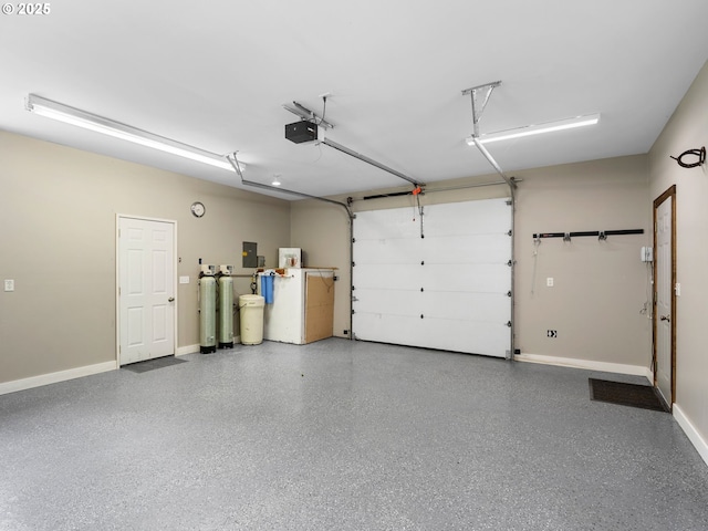 garage with baseboards, a garage door opener, and electric panel