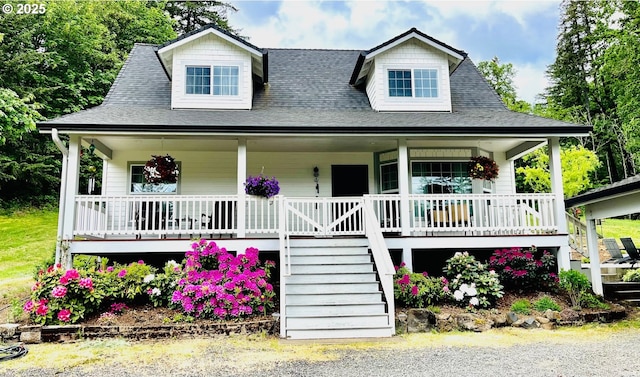 view of front of home with a shingled roof, covered porch, and stairway