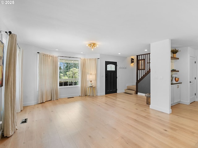 interior space featuring light wood-style floors, baseboards, stairway, and recessed lighting