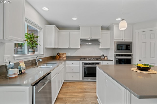 kitchen with stainless steel appliances, decorative light fixtures, white cabinets, and sink