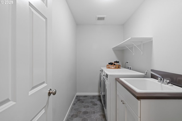 laundry room featuring cabinets, washing machine and clothes dryer, and sink