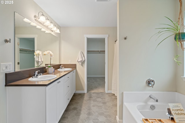 bathroom with a washtub and vanity