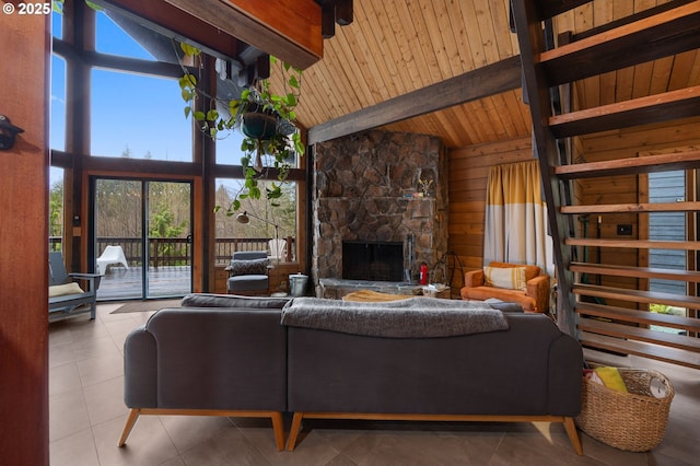 living room with wooden walls, beam ceiling, a fireplace, wooden ceiling, and tile patterned floors