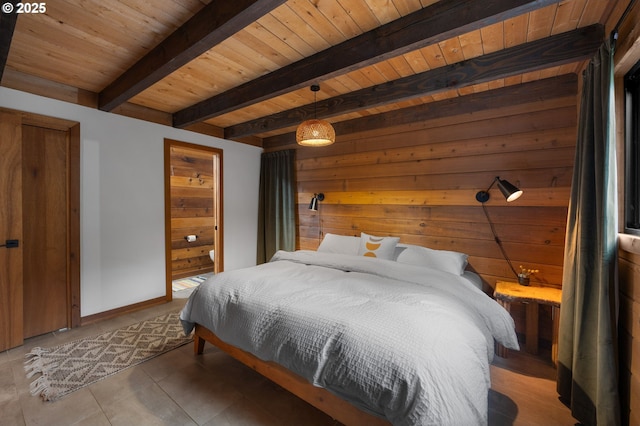 bedroom featuring beamed ceiling, wooden walls, wood ceiling, and ensuite bathroom