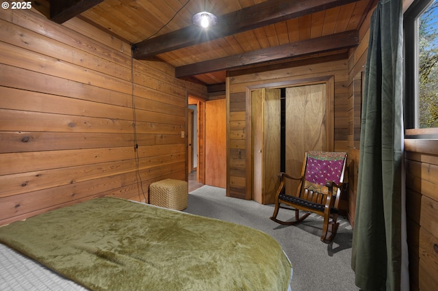 carpeted bedroom with wooden ceiling, beamed ceiling, a closet, and wood walls