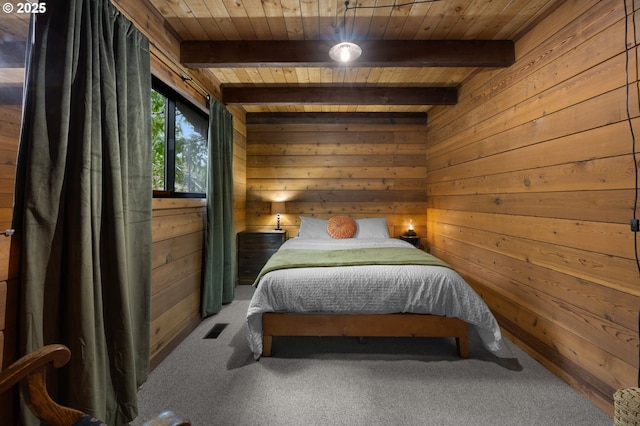 carpeted bedroom featuring visible vents, beam ceiling, wooden walls, and wooden ceiling