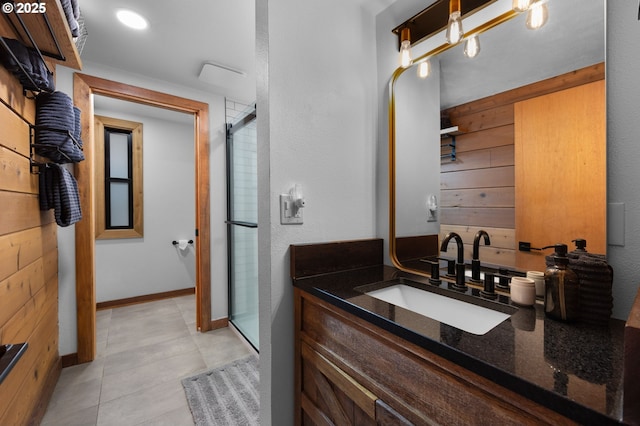 bathroom with vanity, baseboards, and a stall shower