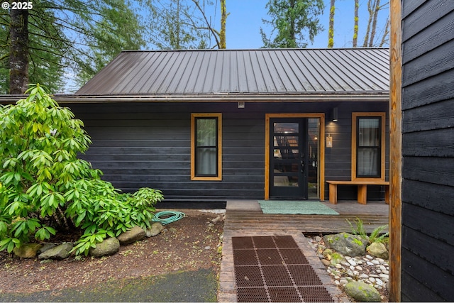 view of exterior entry with a standing seam roof and metal roof