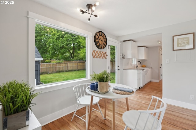 dining space featuring light wood-type flooring and baseboards