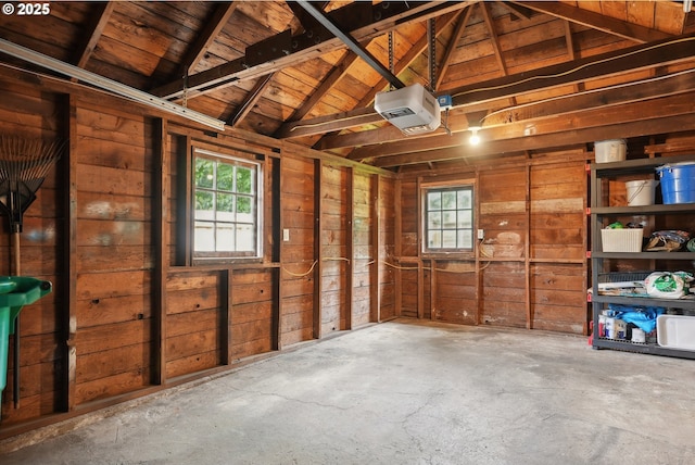 garage featuring a garage door opener and wood walls