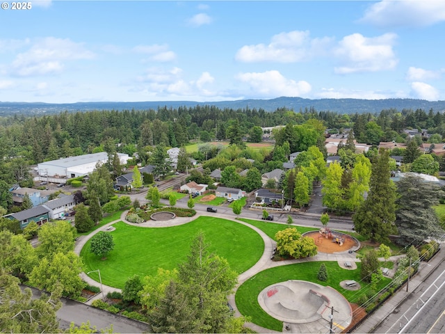 aerial view of residential area with a mountainous background and a heavily wooded area