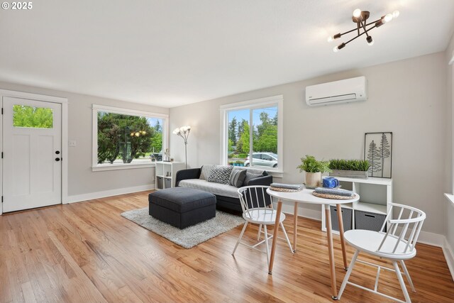 living area with a wall mounted AC, wood finished floors, and baseboards