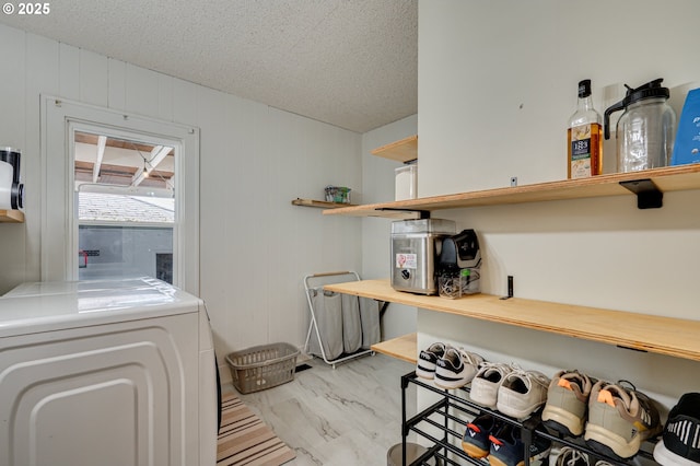 laundry area with laundry area, a textured ceiling, and separate washer and dryer