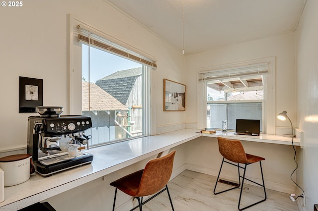 home office featuring baseboards, built in desk, and marble finish floor