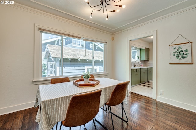 dining space featuring crown molding, dark wood finished floors, baseboards, and a notable chandelier