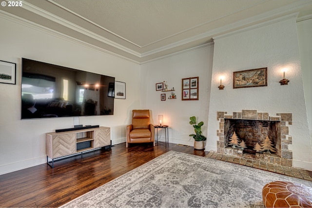 living room featuring baseboards, ornamental molding, a fireplace with flush hearth, and wood finished floors