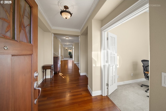 corridor featuring dark wood-type flooring, crown molding, and baseboards