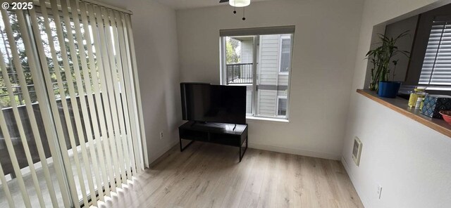 sitting room with a ceiling fan, wood finished floors, and baseboards