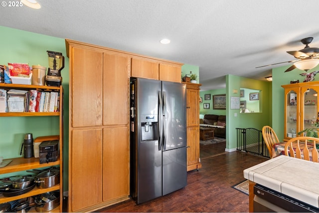 kitchen with appliances with stainless steel finishes, tile counters, ceiling fan, a textured ceiling, and dark wood-style flooring