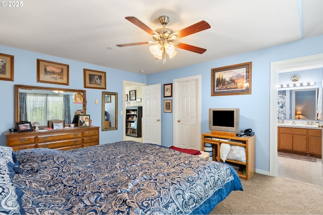 bedroom with light colored carpet, connected bathroom, a ceiling fan, and baseboards