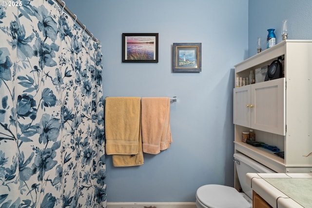 bathroom featuring toilet, baseboards, vanity, and a shower with curtain