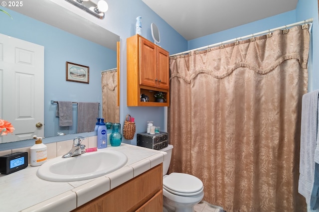 full bath with toilet, vanity, and tile patterned floors