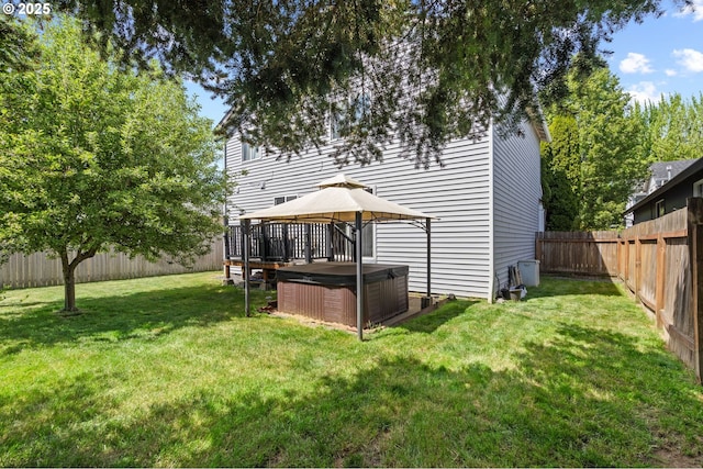 rear view of house with a hot tub and a gazebo