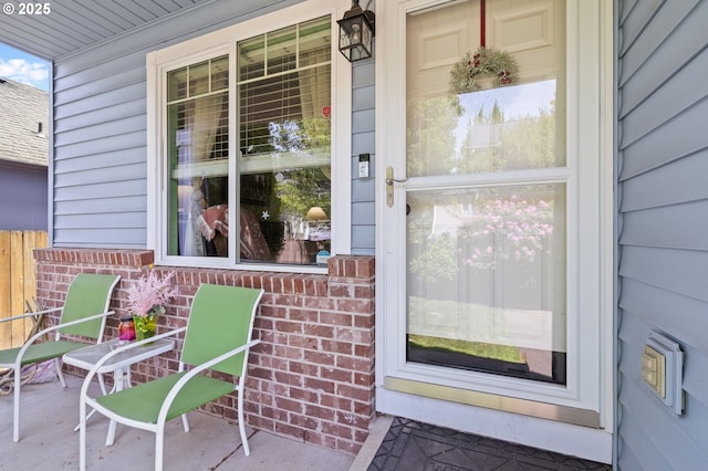 entrance to property with covered porch and brick siding