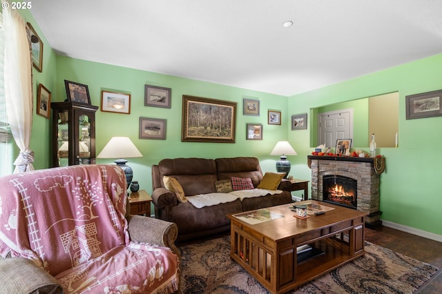 living area with wood finished floors, baseboards, and a fireplace