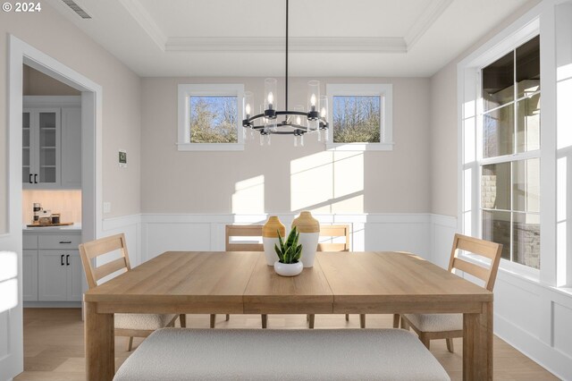 4998 NW Deerhaven Ter, Portland, OR 97229 - dining area featuring a chandelier, plenty of natural light, light wood-type flooring, a raised ceiling, and a decorative wall