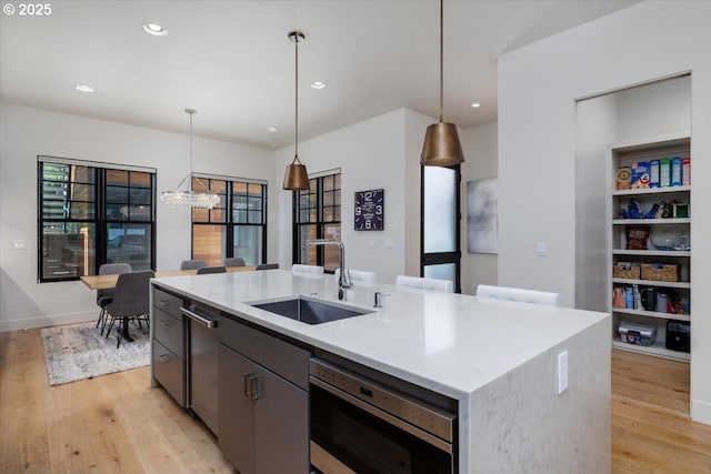 542 4th St, Lake Oswego, OR 97034 - kitchen with light wood-style flooring, appliances with stainless steel finishes, hanging light fixtures, a center island with sink, and a chandelier