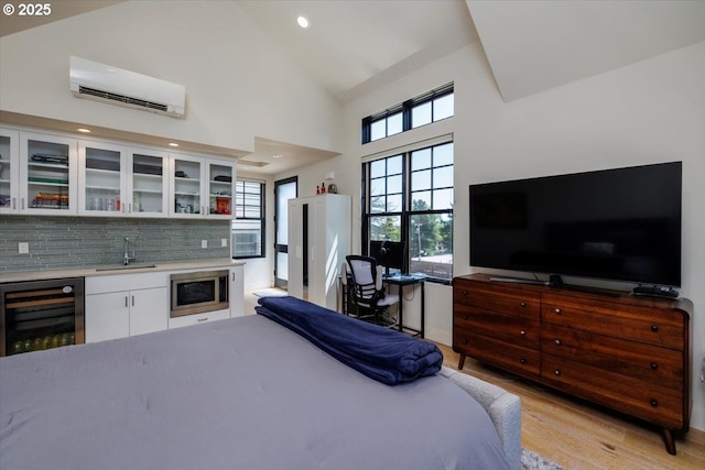 542 4th St, Lake Oswego, OR 97034 - bedroom featuring wine cooler, a wall unit AC, light wood finished floors, bar area, and high vaulted ceiling