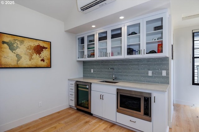 542 4th St, Lake Oswego, OR 97034 - bar area with stainless steel microwave, wine cooler, decorative backsplash, a wall mounted AC, and light wood-type flooring