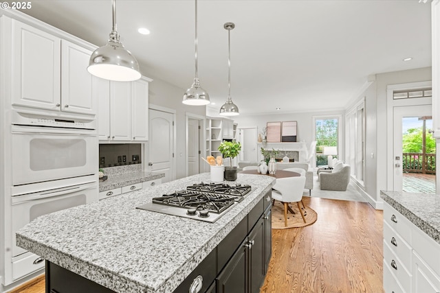1206 NW Mayfield Rd, Portland, OR 97229 - kitchen with double oven, stainless steel gas cooktop, white cabinets, light wood-style flooring, and recessed lighting