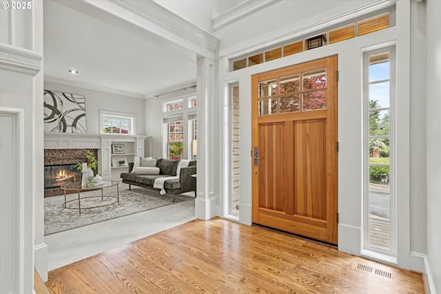 1206 NW Mayfield Rd, Portland, OR 97229 - entrance foyer with crown molding, a glass covered fireplace, and wood finished floors