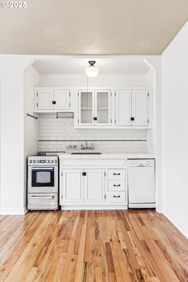 kitchen featuring stainless steel range with gas cooktop, white cabinetry, dishwasher, and backsplash