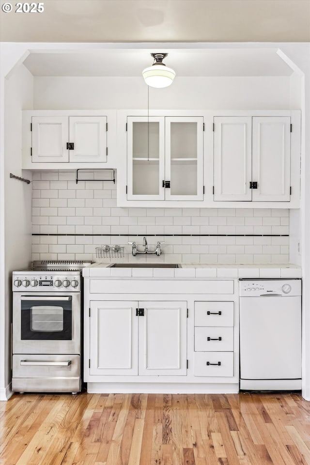 kitchen featuring dishwasher, decorative backsplash, tile counters, and stainless steel gas stove