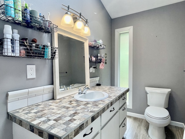 755 17th Ave, Coos Bay, OR 97420 - bathroom featuring vanity, toilet, baseboards, and wood finished floors