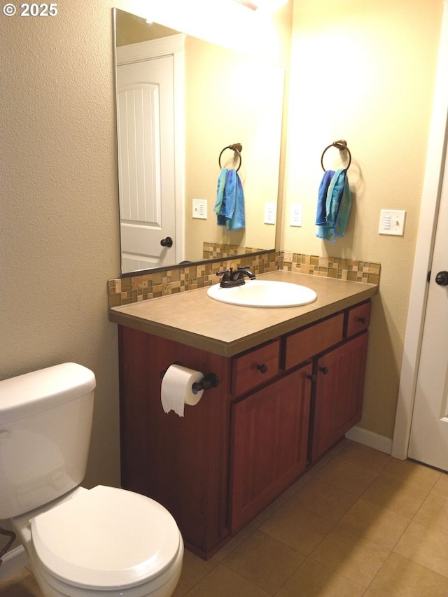 bathroom with tile patterned floors, toilet, tasteful backsplash, and vanity