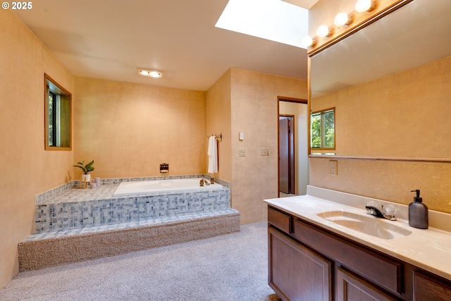 full bath with a skylight, a garden tub, and vanity