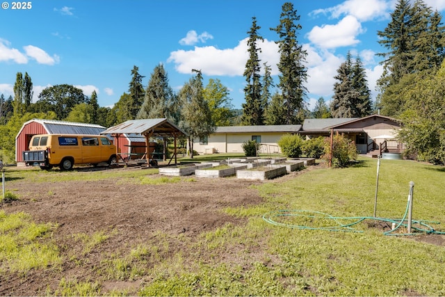 view of front of home featuring a front yard, a garden, and an outdoor structure