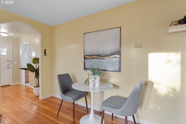 dining area with baseboards, attic access, and hardwood / wood-style floors