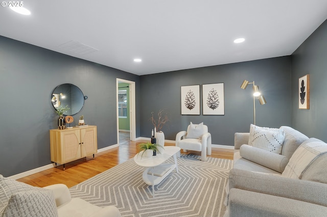 living room with recessed lighting, baseboards, light wood-type flooring, and visible vents